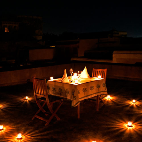 image of dining table outside lit by candle light