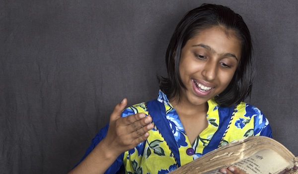 Cheerful Indian Girl Reading Holy Book