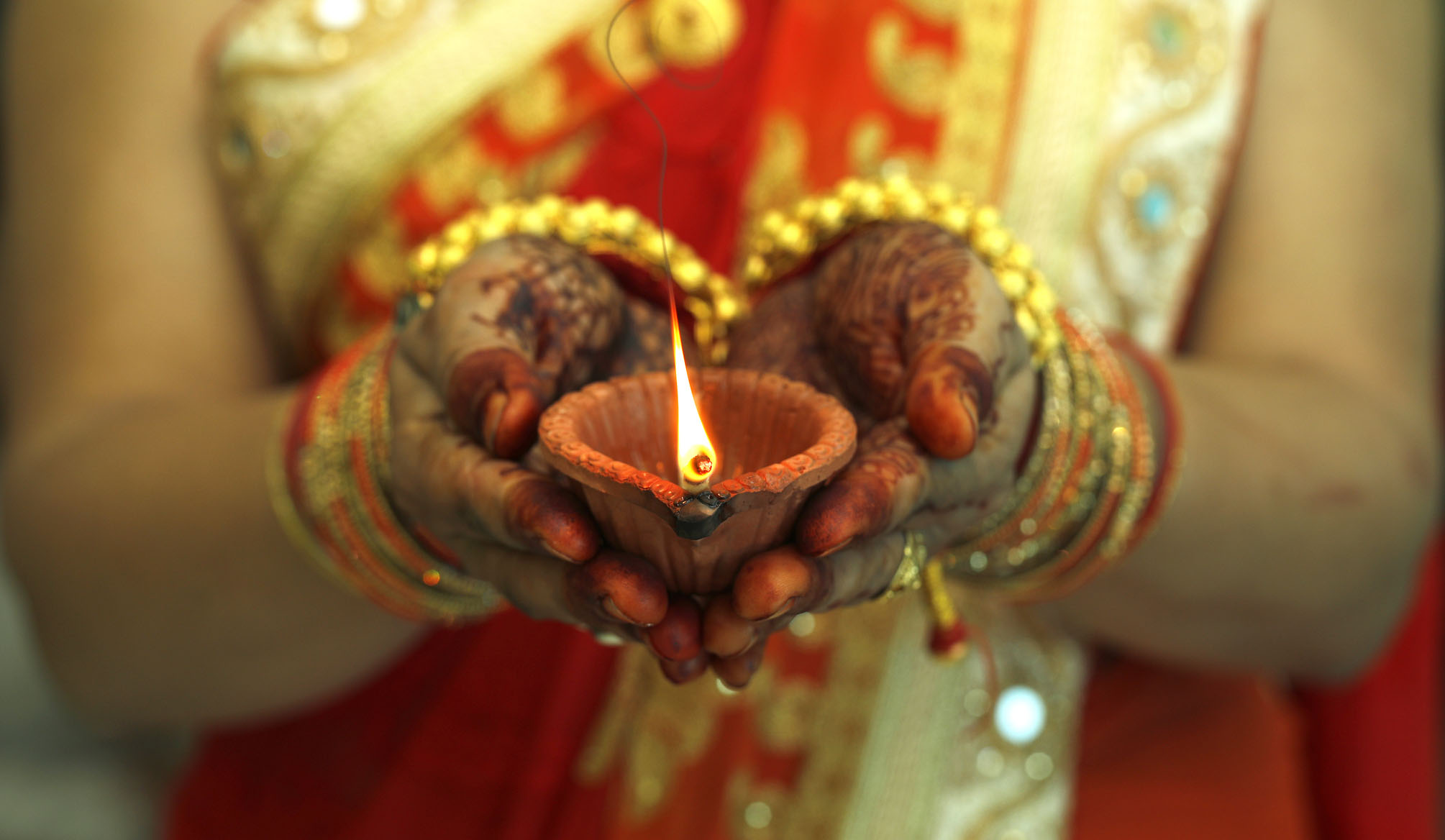 Christmas in India | Indian woman holding Diwali oil lamp