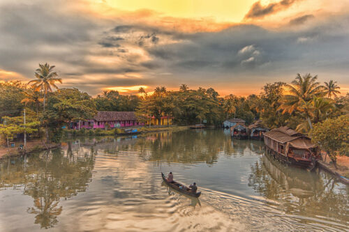 A beautiful image of a boat cruising at sunset in Kerala