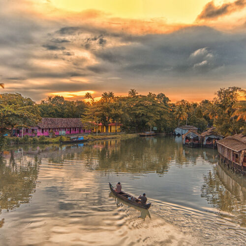 A beautiful image of a boat cruising at sunset in Kerala